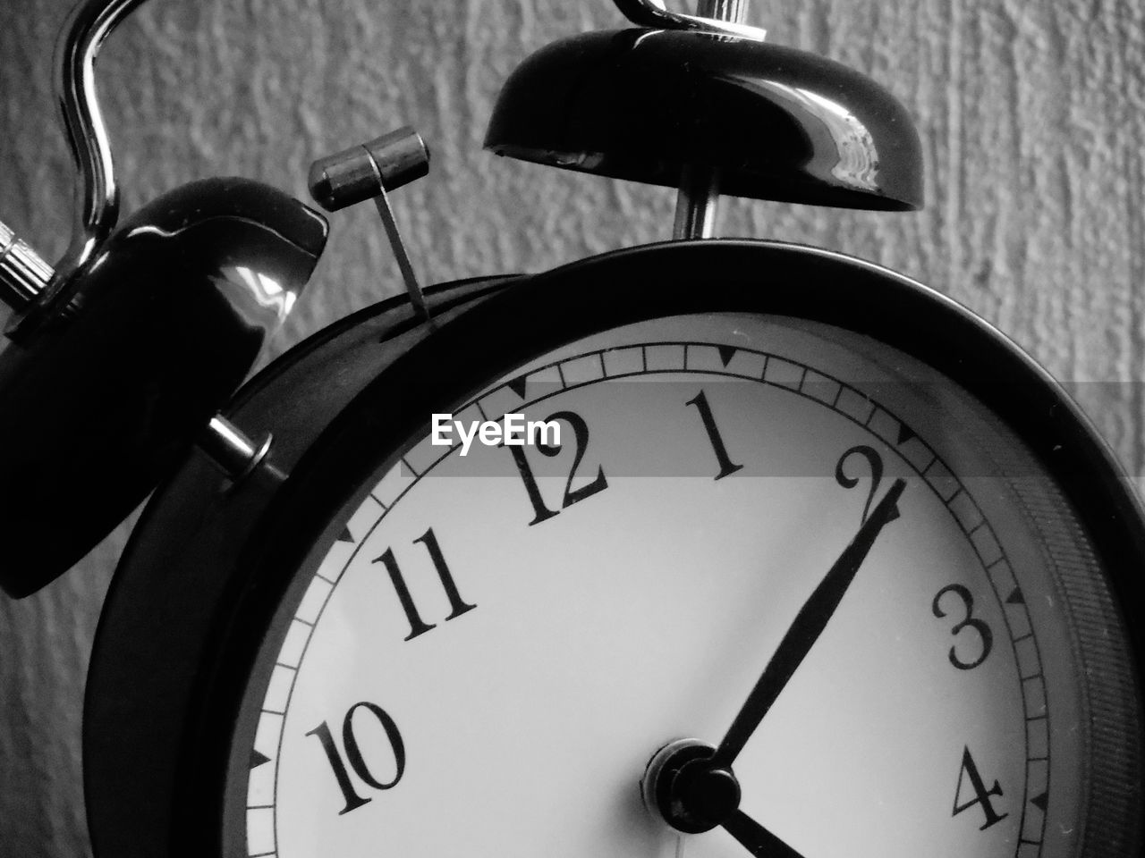 Close-up of alarm clock against wall