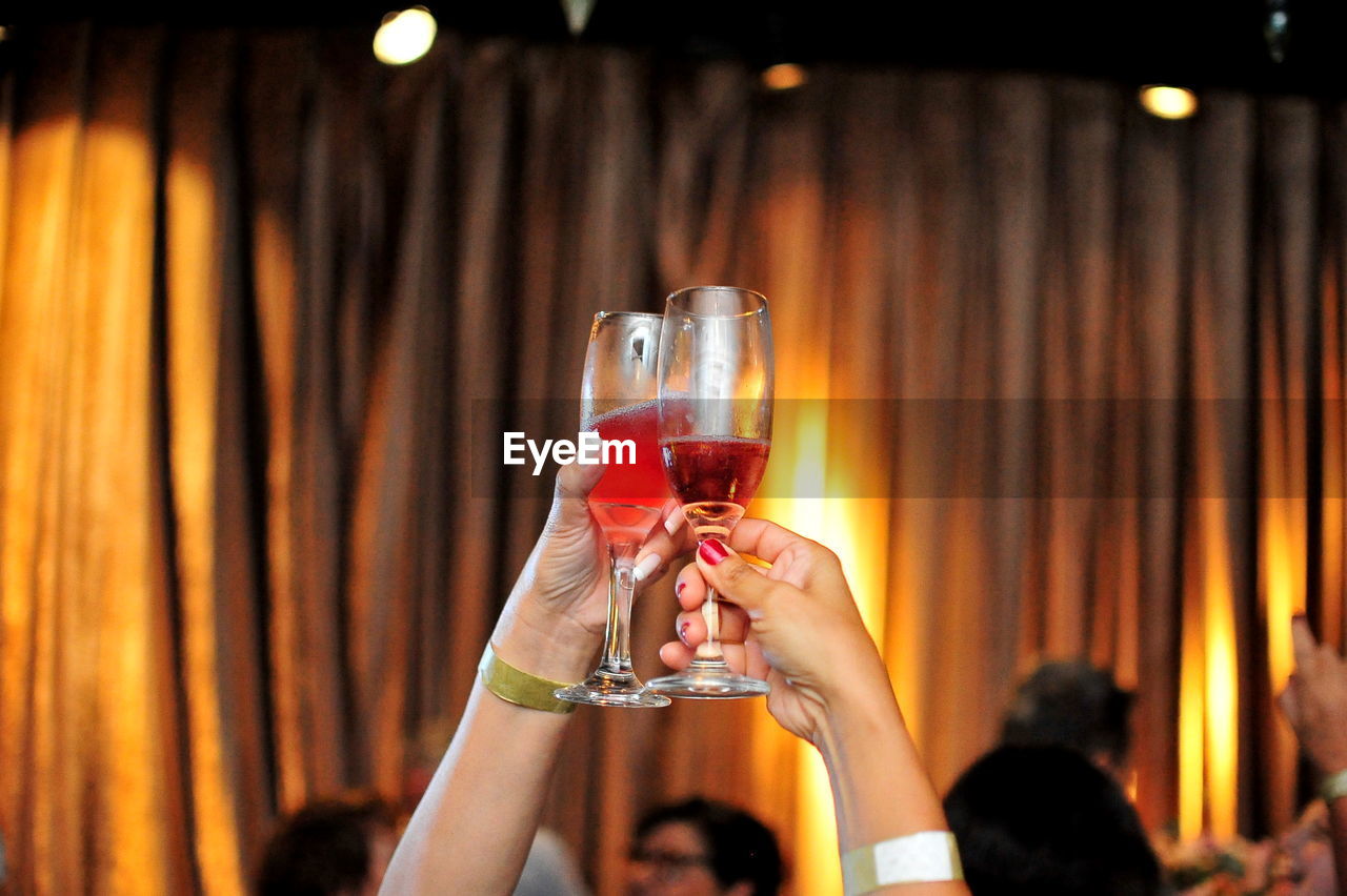 Cropped image of hands toasting drinks at party