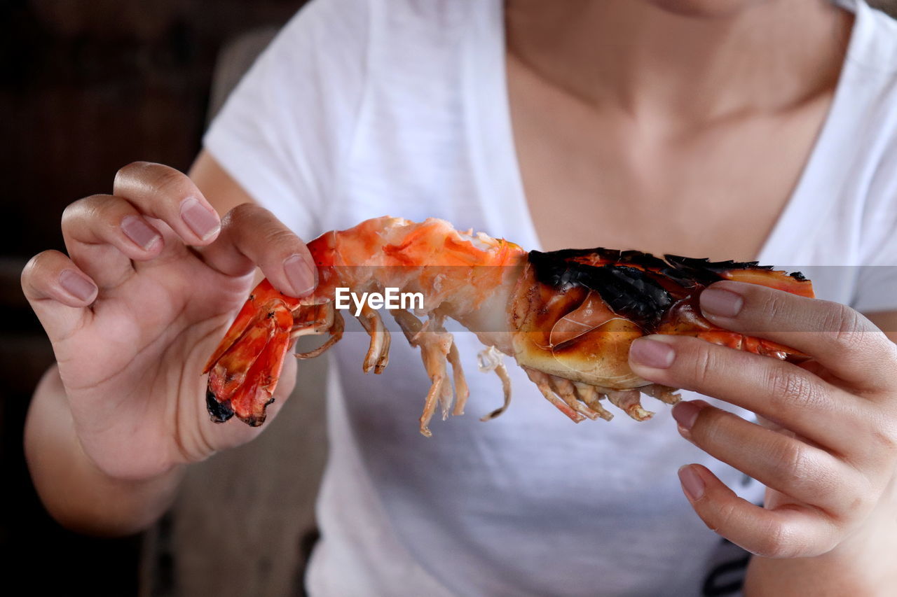 Midsection of woman holding shrimp