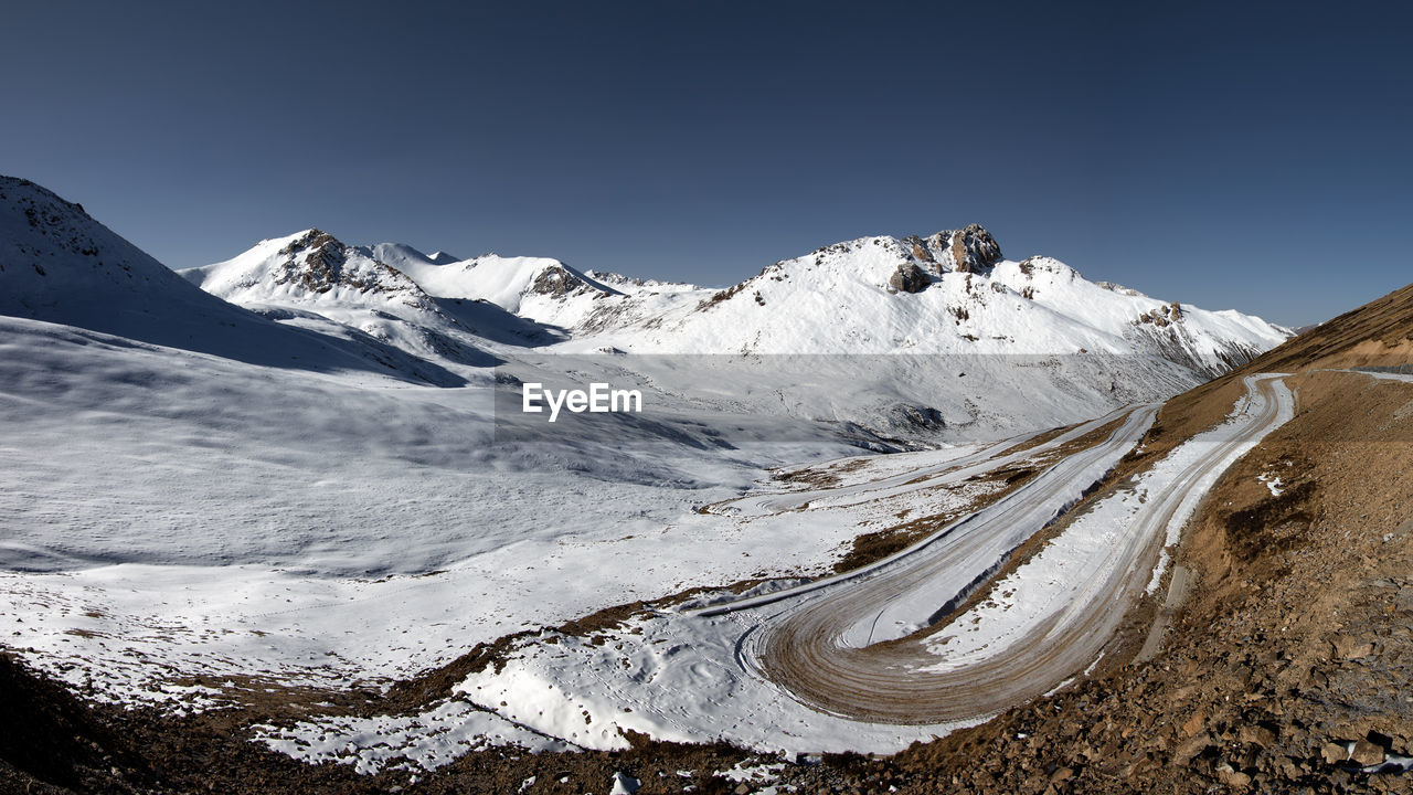 Scenic view of snowcapped mountains against clear sky