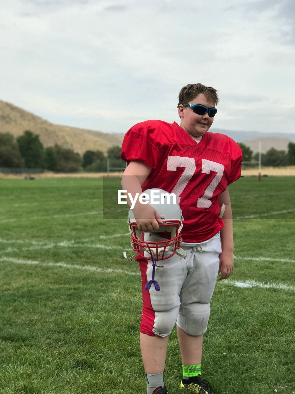 Boy wearing american football uniform on playing field