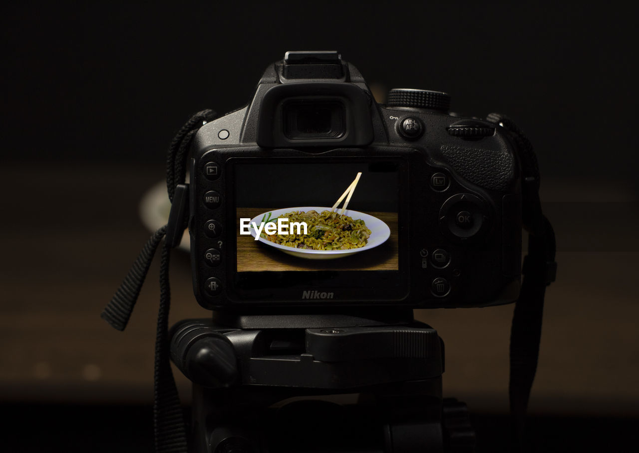 Close-up of camera on table against black background