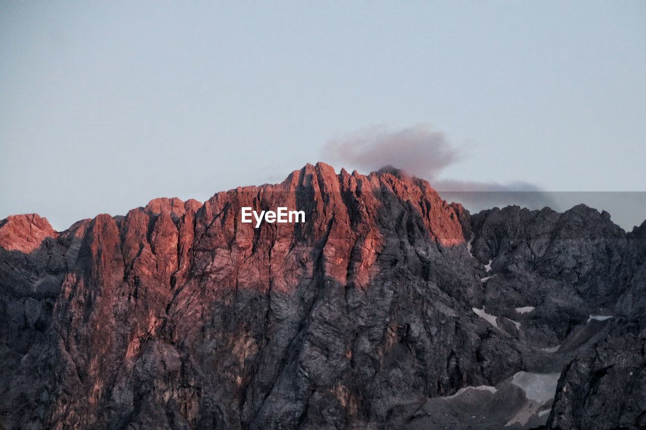 Rock formations on mountain against sunset sky