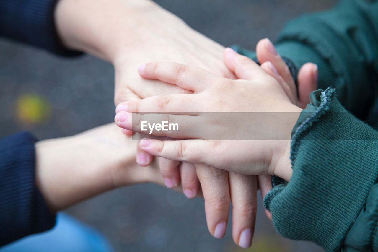 Cropped image of people stacking hands