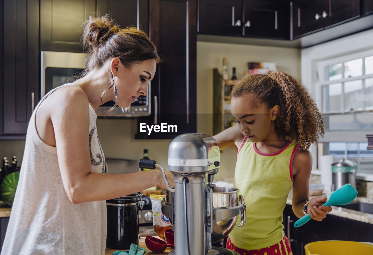 Mother and daughter baking in kitchen