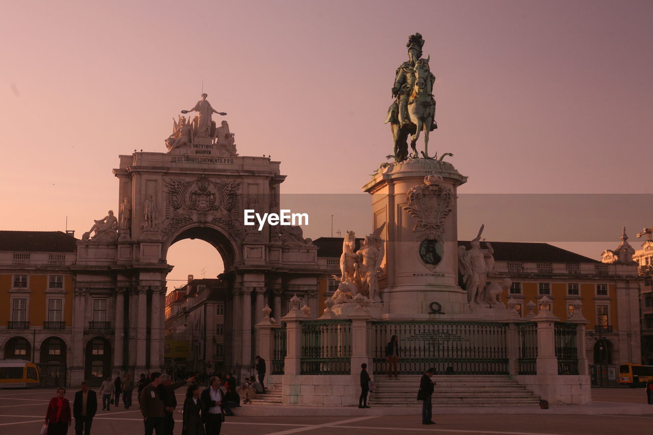 Low angle view of statue and building against sky at praca do comercio