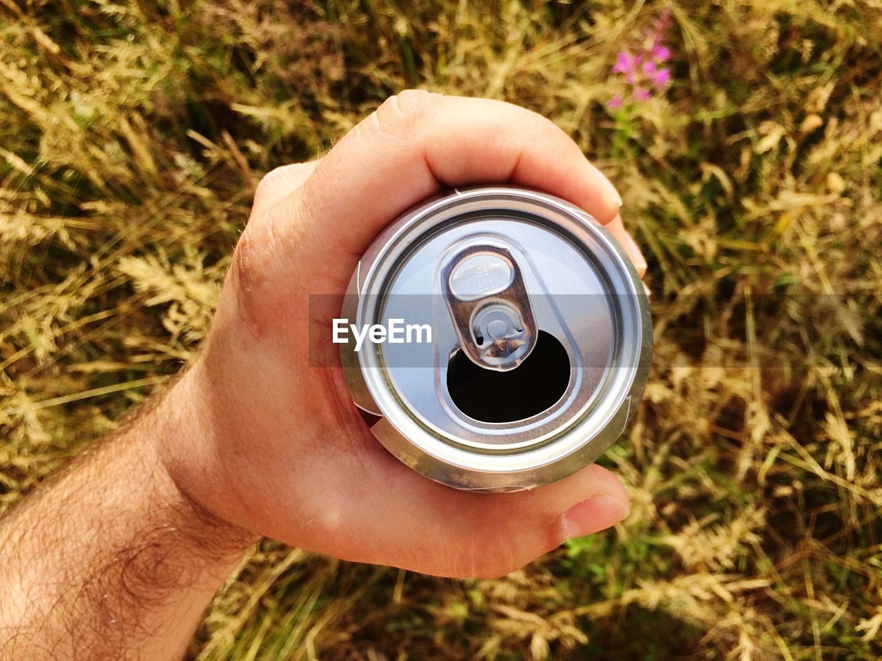 Close-up of man holding beer can
