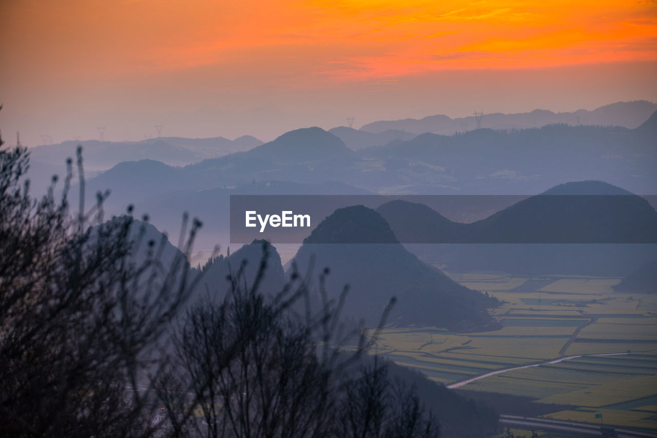 Scenic view of mountains against orange sky