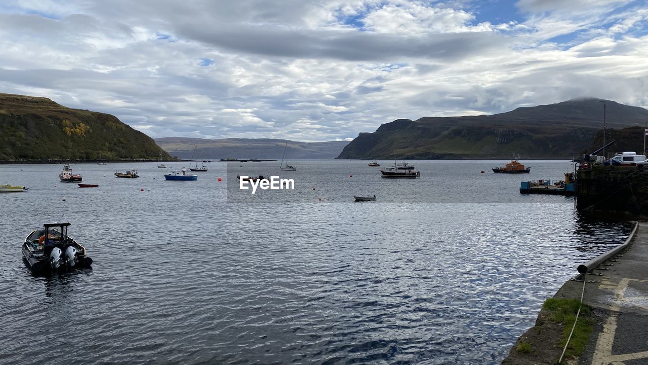 water, transportation, nautical vessel, sky, mountain, cloud, sea, mode of transportation, nature, scenics - nature, travel, beauty in nature, travel destinations, vehicle, body of water, day, coast, bay, holiday, vacation, tourism, trip, beach, land, outdoors, mountain range, tranquility, environment, boating, shore, tranquil scene, landscape, architecture, boat, harbor, ship, leisure activity, idyllic, tourist, bay of water, city
