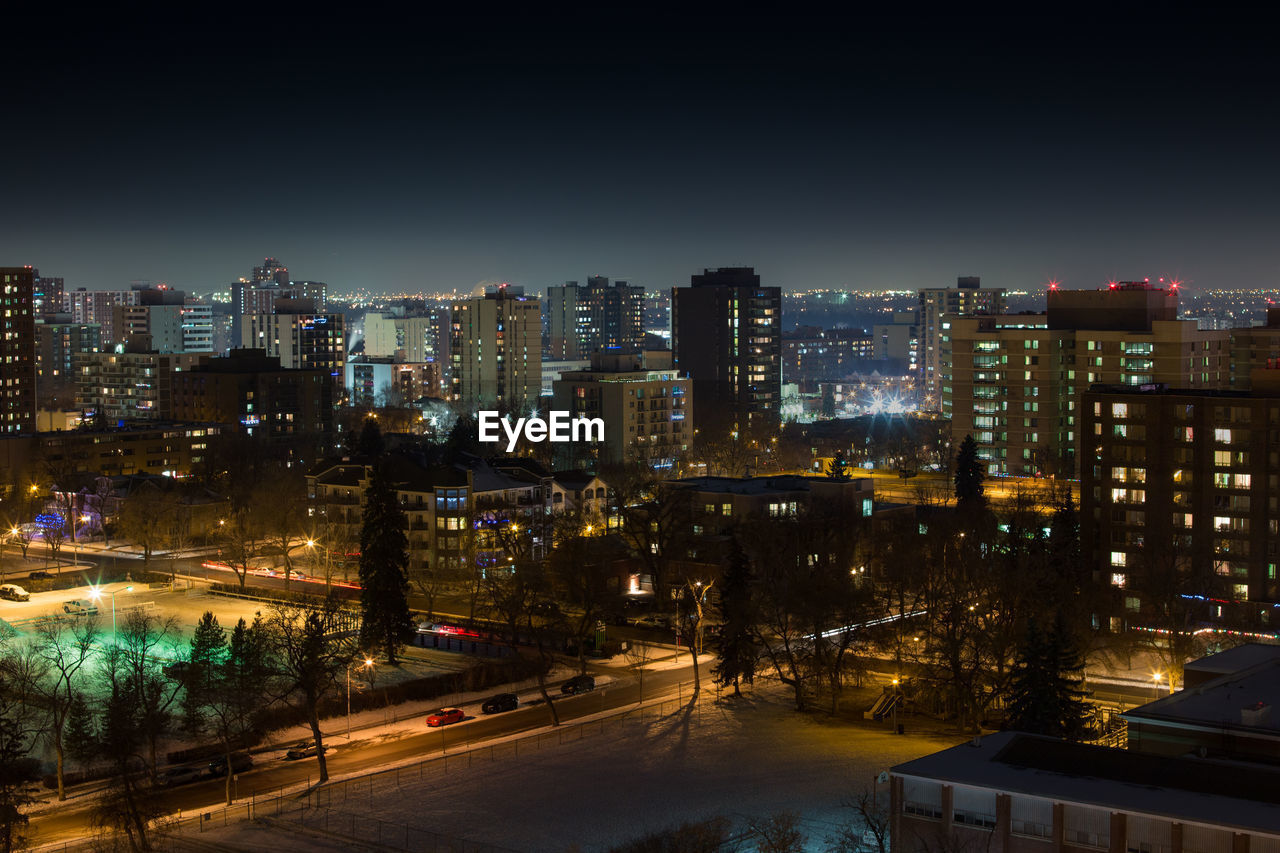 ILLUMINATED CITYSCAPE AGAINST SKY AT NIGHT