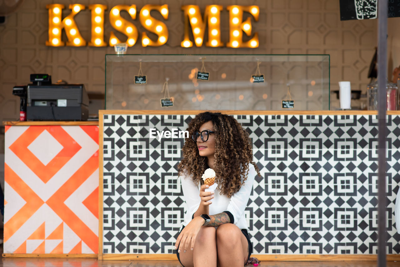 Young woman eating ice cream outdoors