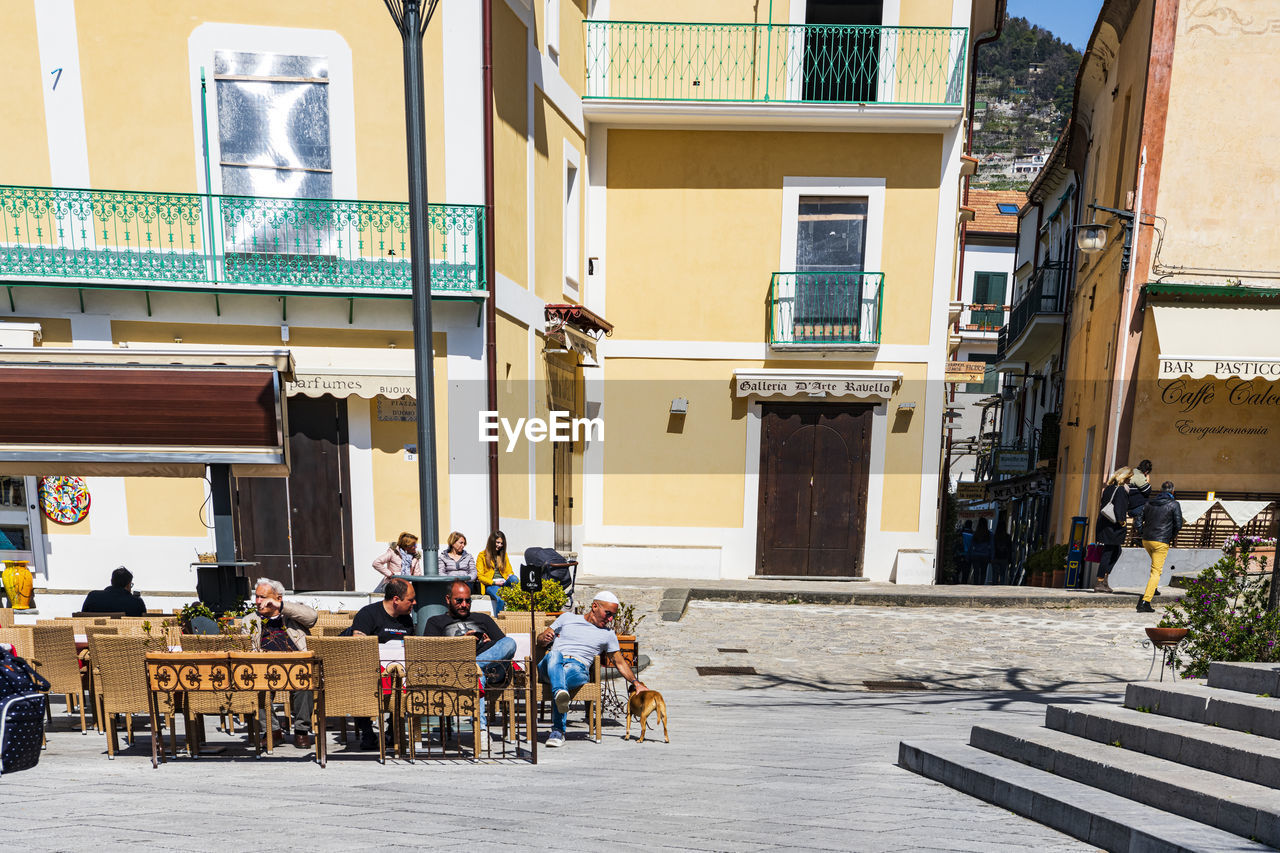 People on street against buildings in city in ravello, italy