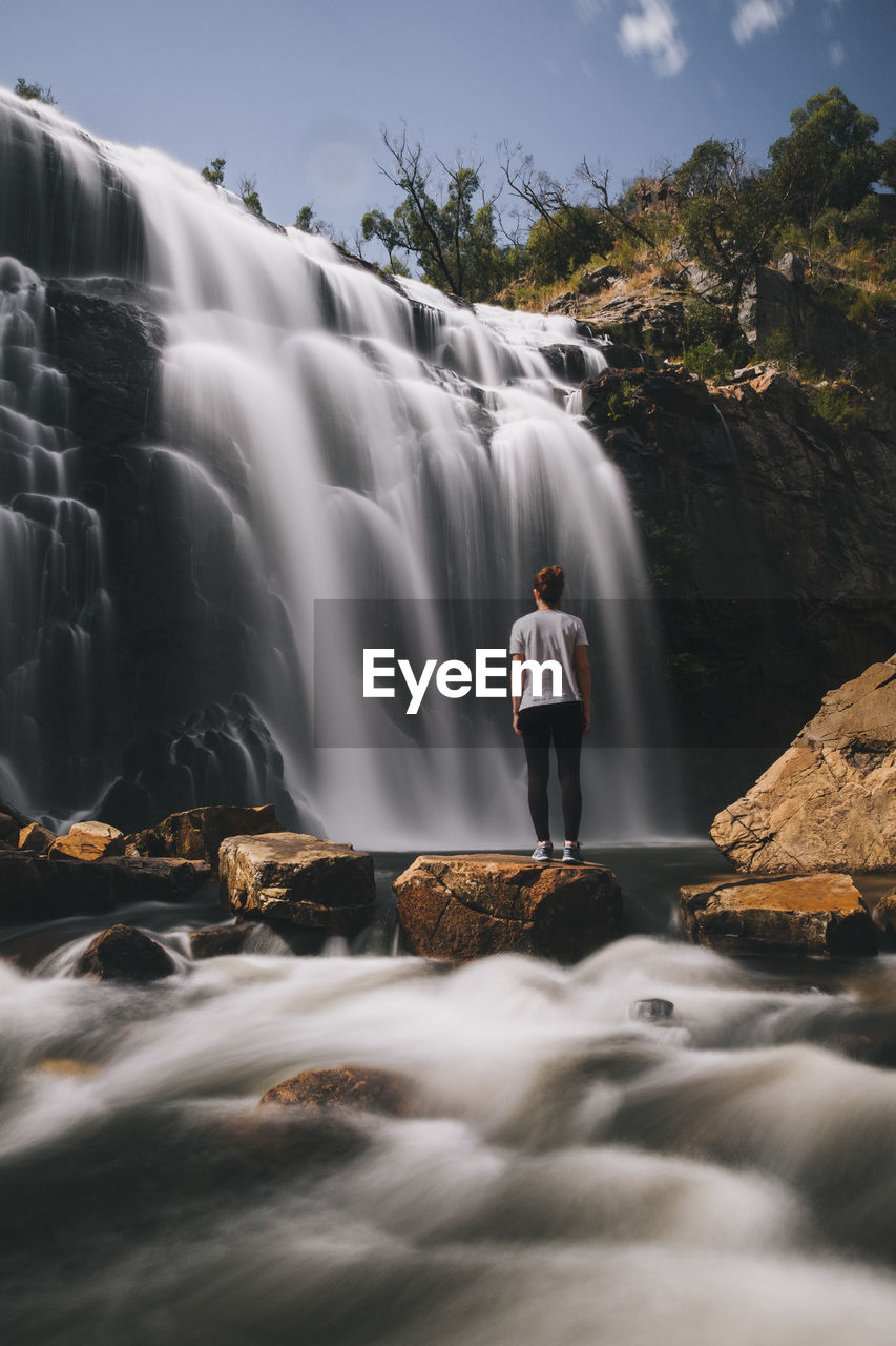 Young woman stares at mackenzie waterfalls at the grampians national park, victoria, australia