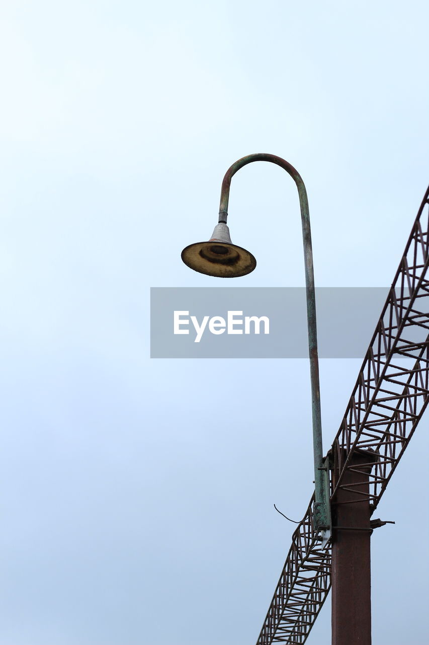 LOW ANGLE VIEW OF CRANES AGAINST CLEAR SKY