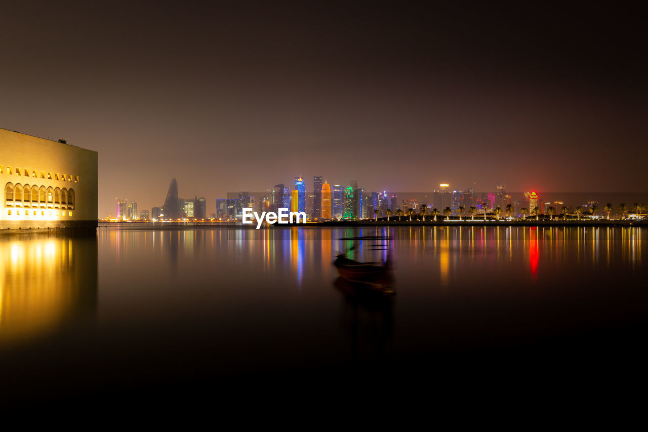 Illuminated skyline of doha, qatar with illuminated museum of islamic art at night