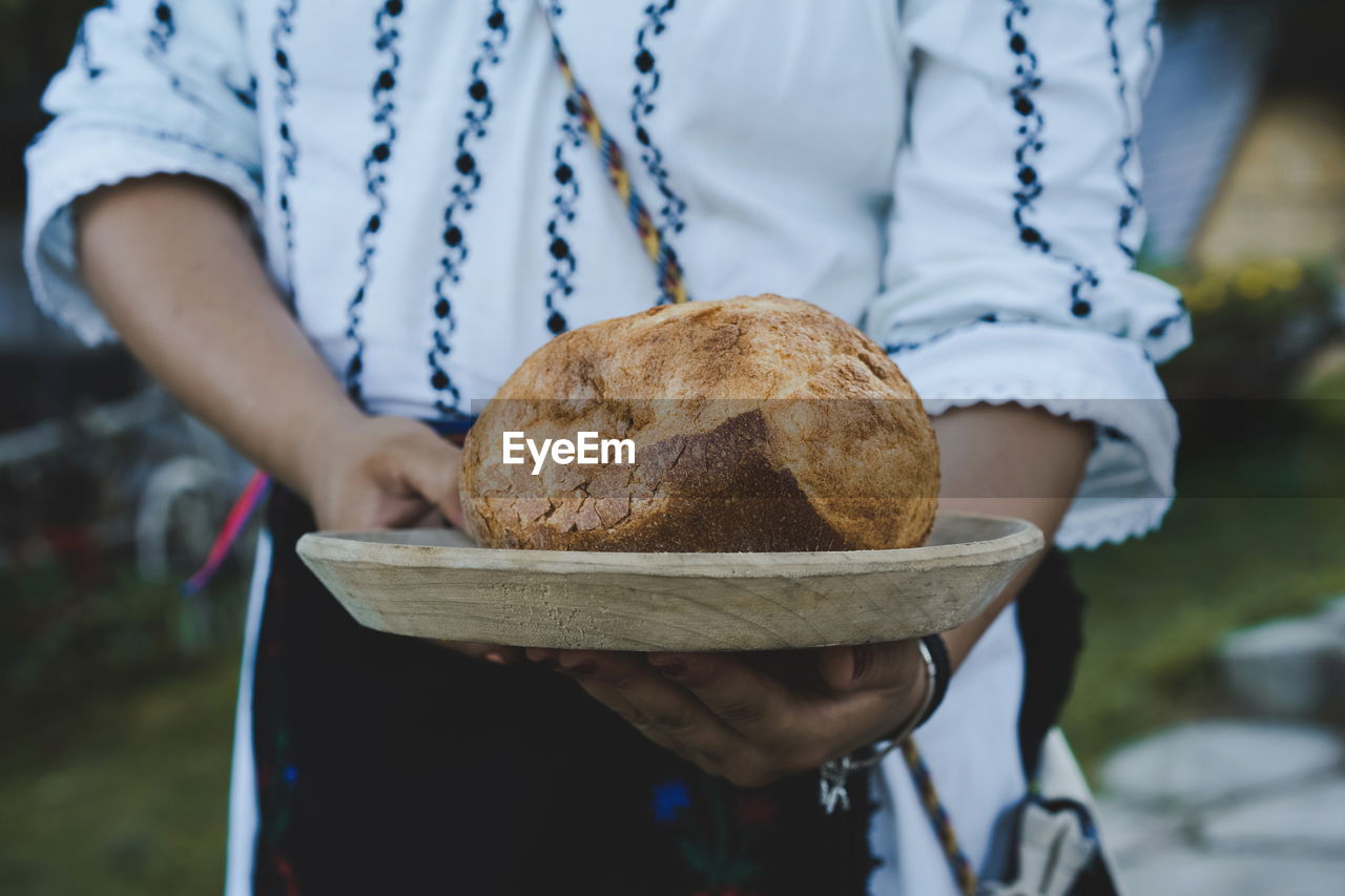 Close-up of hand holding bread on plate