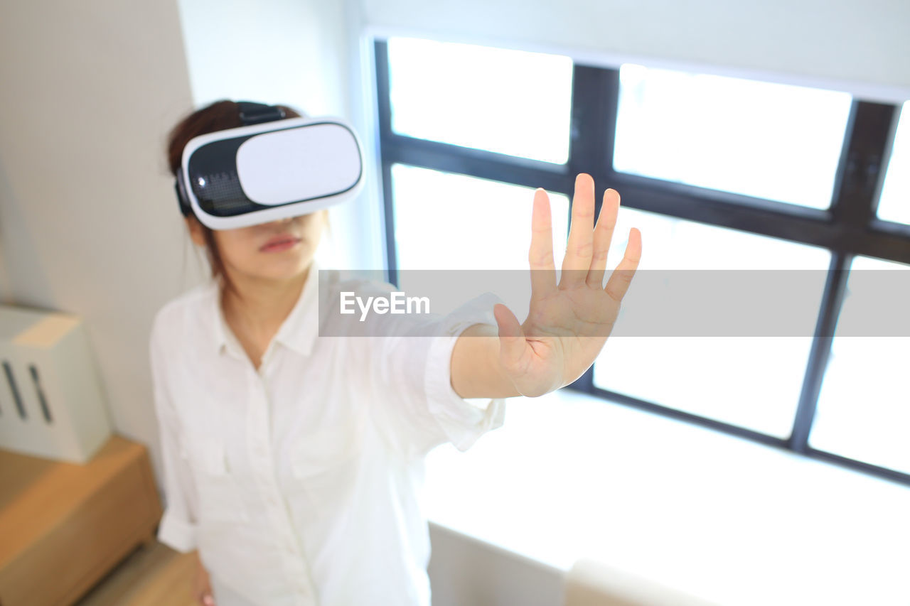 Woman using virtual reality simulator at home