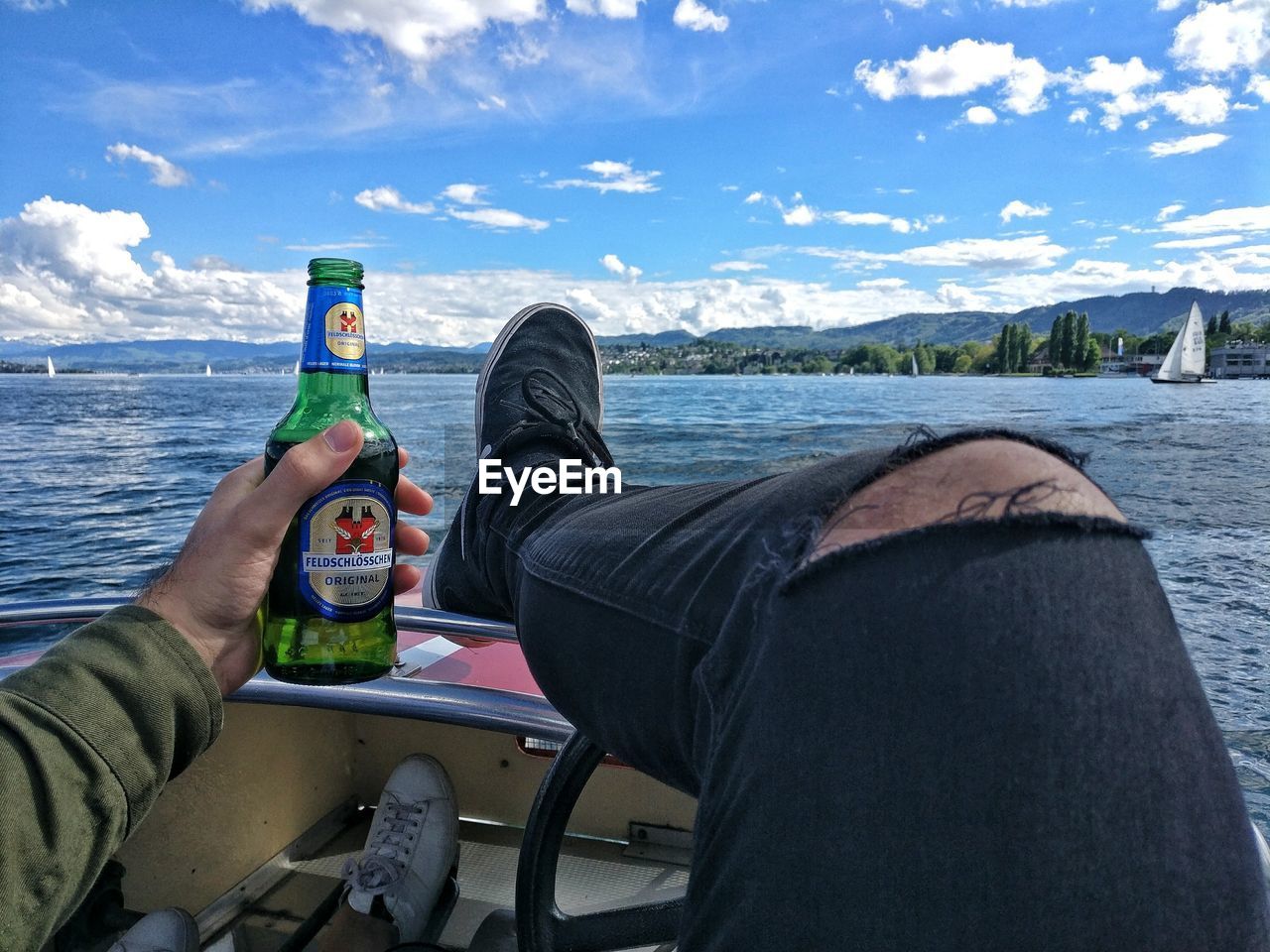 LOW SECTION OF MAN SITTING IN FRONT OF SEA