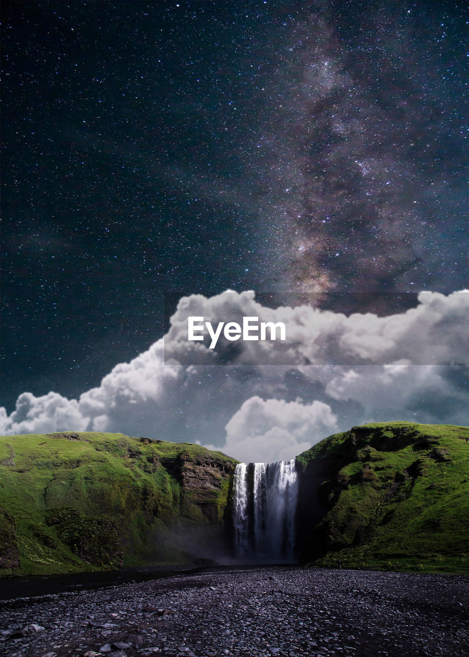 Scenic view of waterfall against sky at night