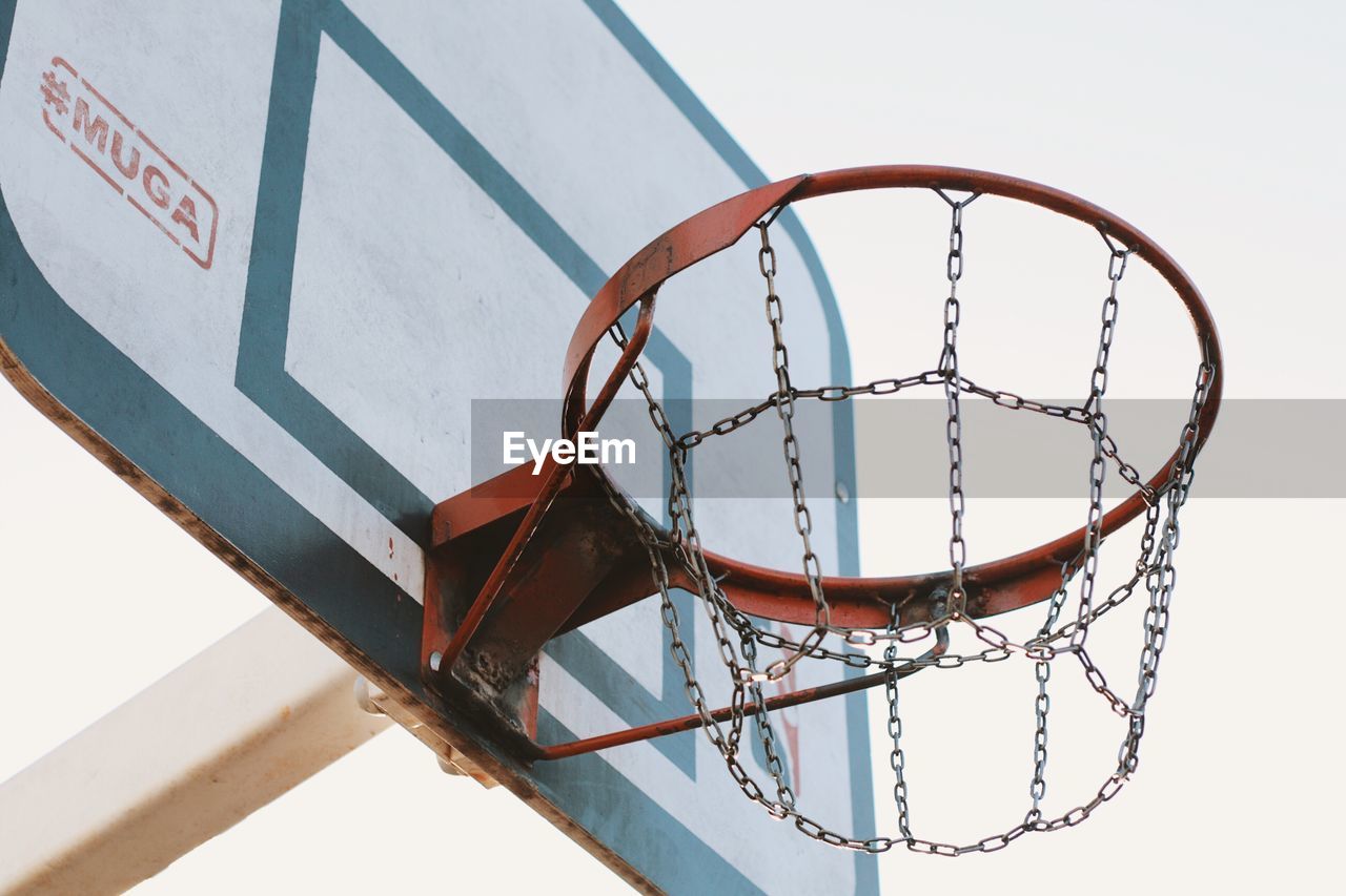 LOW ANGLE VIEW OF BASKETBALL HOOP AGAINST WALL