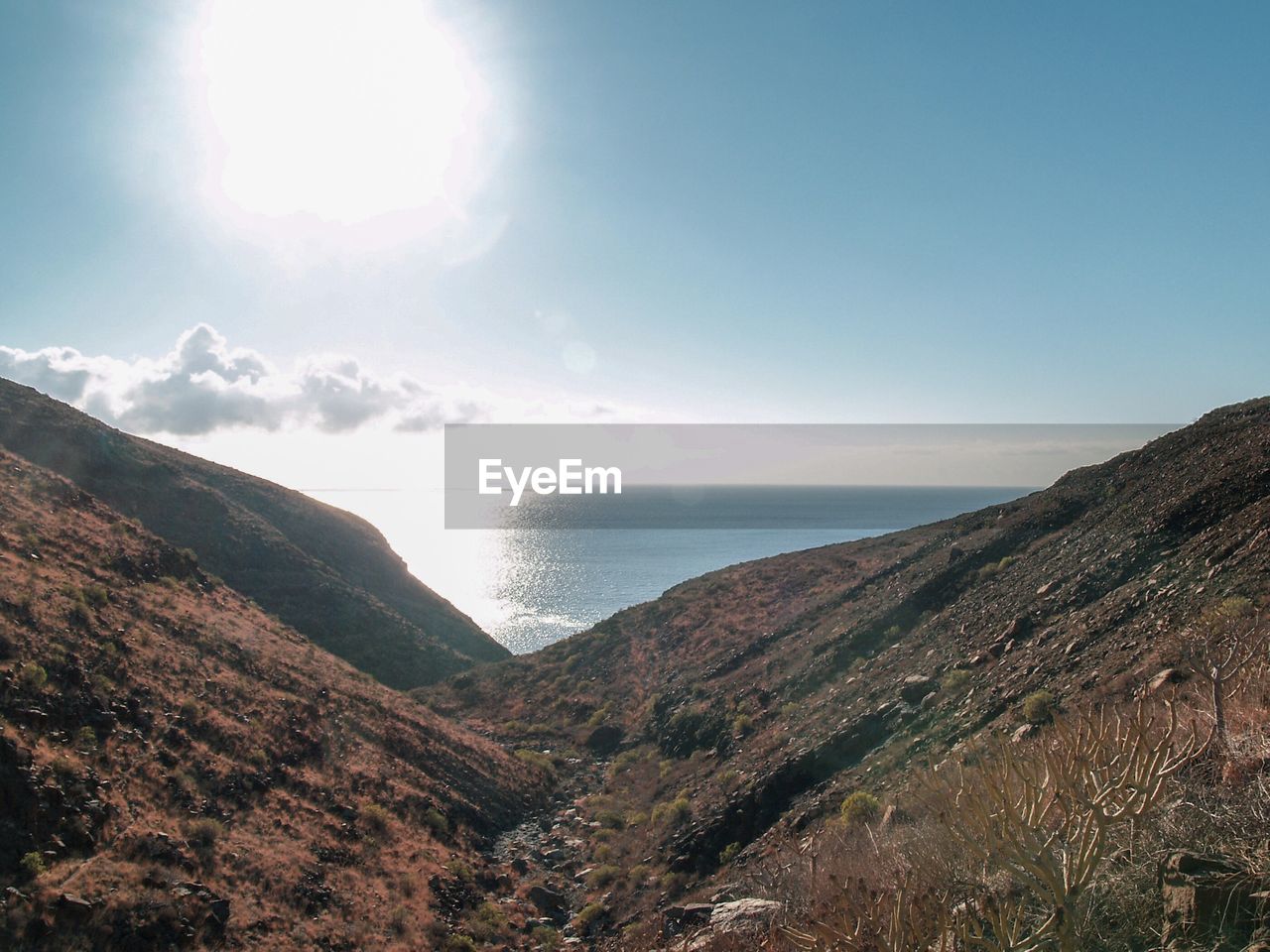 Scenic view of sea and mountains against sky