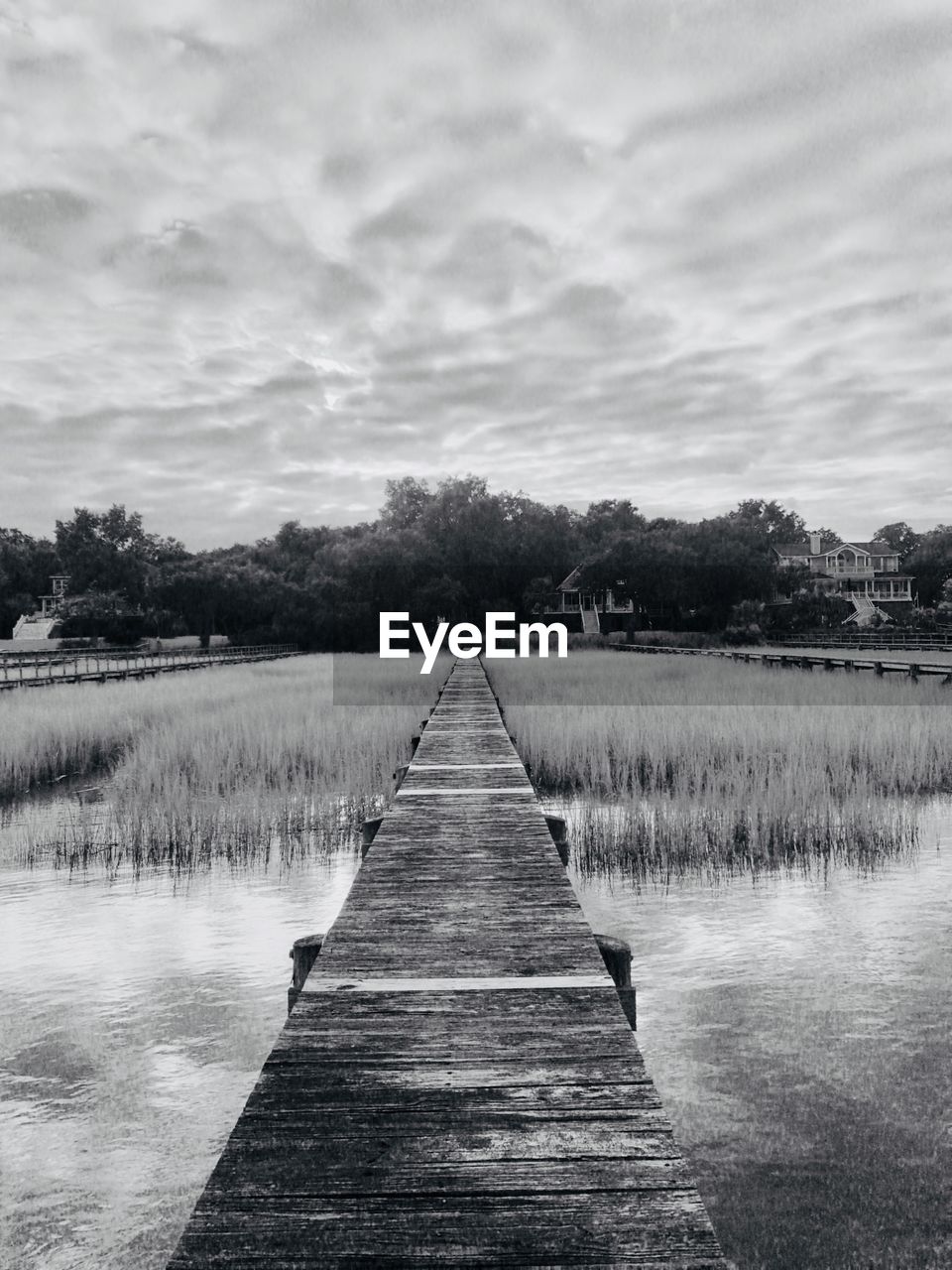 WOODEN PIER OVER LAKE AGAINST SKY