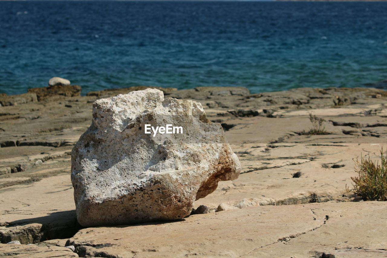 Close-up of rocks on beach against sky