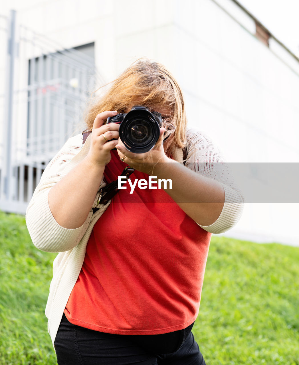 Body positive. portrait of overweight woman taking pictures with a camera in the park