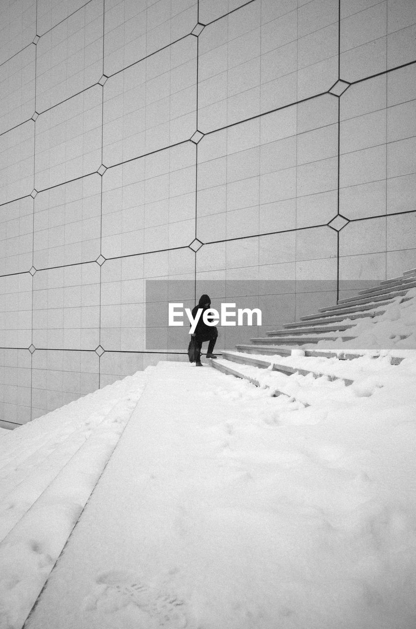 Woman walking on snow covered steps during winter