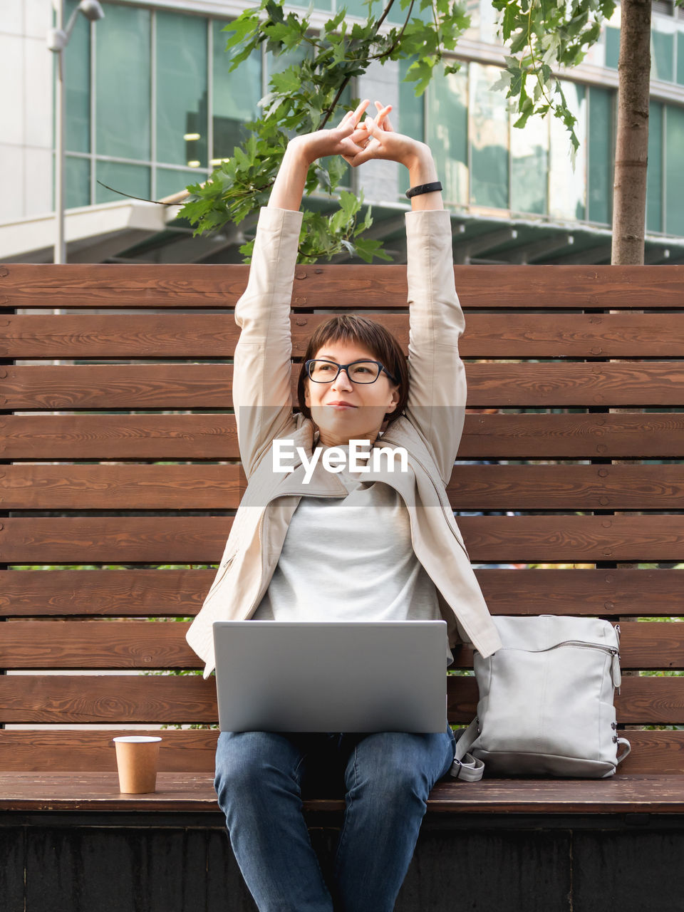 Freelance business woman sits in park with laptop. urban lifestyle. working remotely.