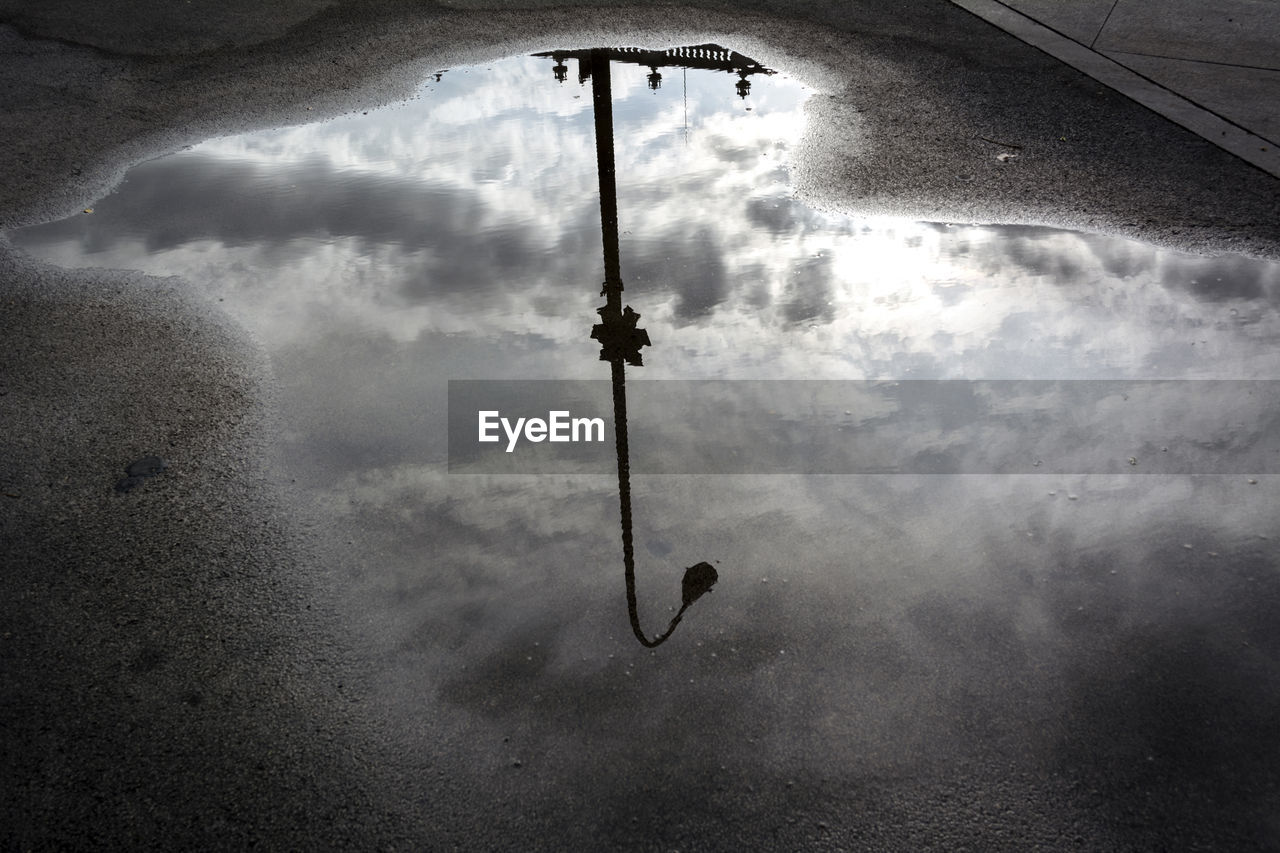 LOW ANGLE VIEW OF STREET LIGHTS AGAINST CLOUDY SKY