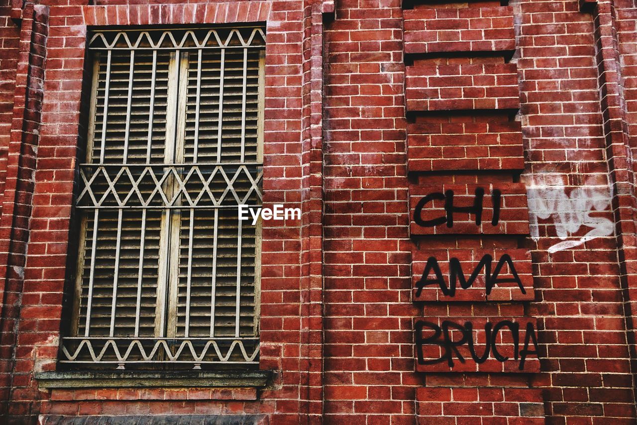 FULL FRAME SHOT OF BRICK WALL WITH RED BUILDING