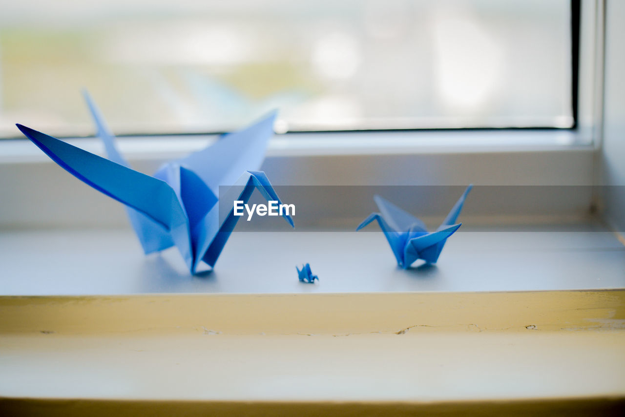 Close-up of paper crafts on window sill