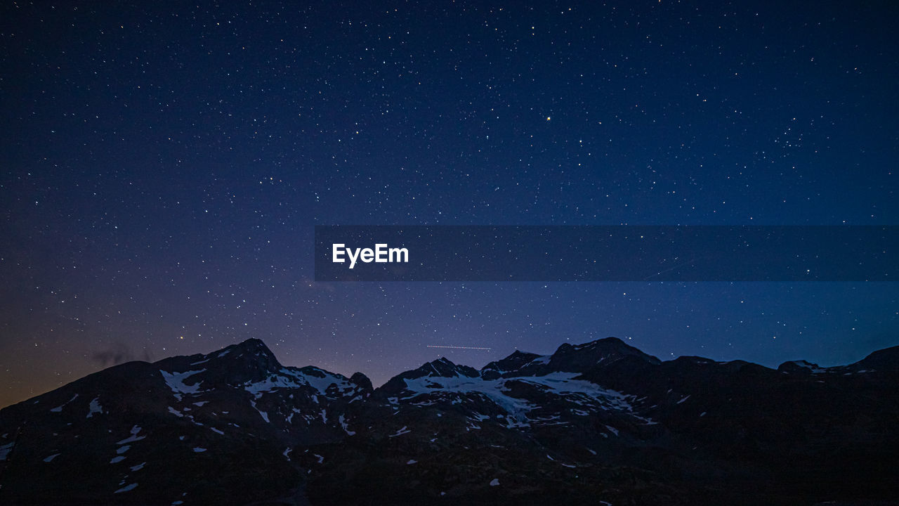 LOW ANGLE VIEW OF SNOWCAPPED MOUNTAIN AGAINST SKY