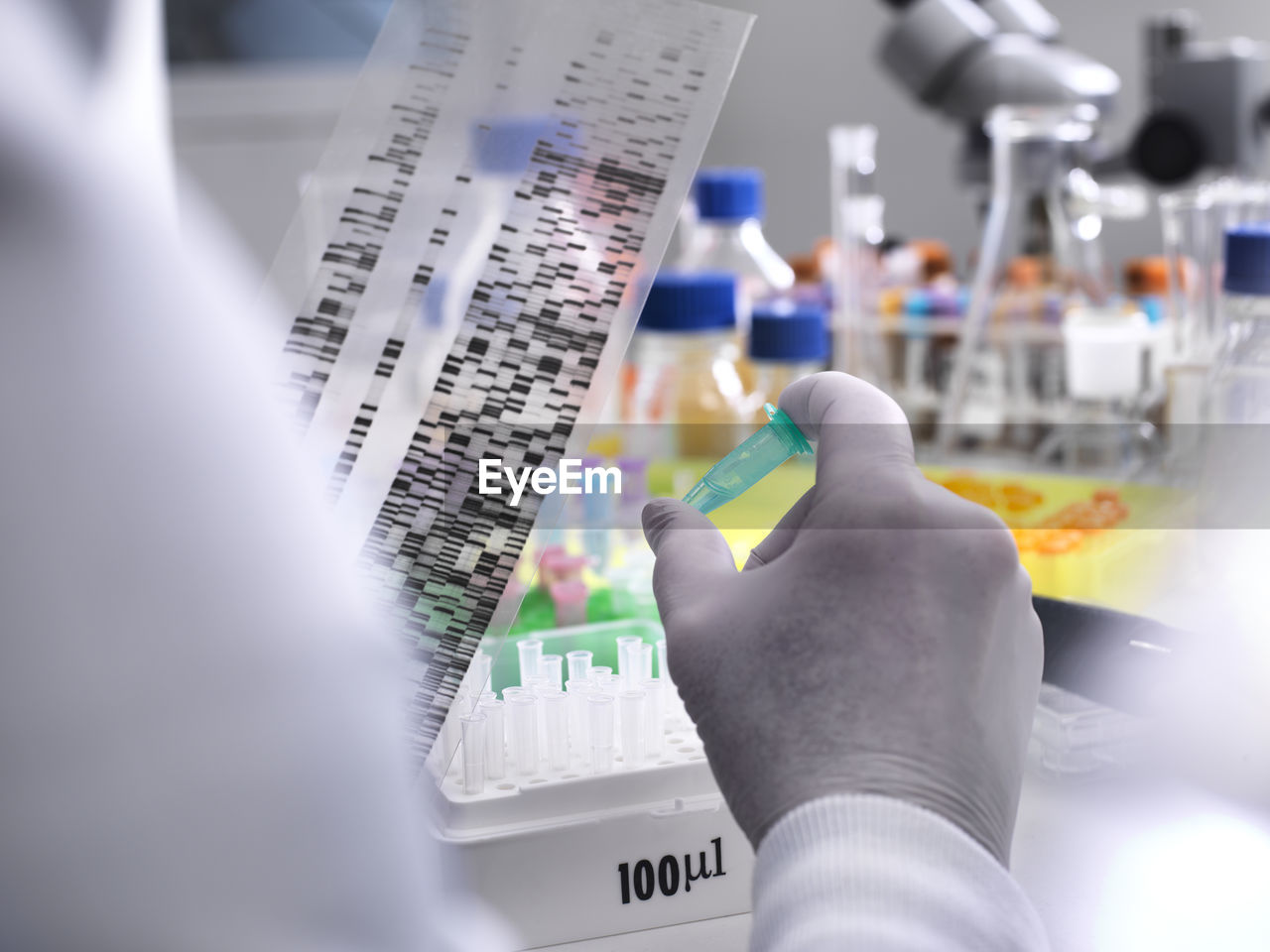 Scientist holding a dna gel revealing the genetic make up of the specimen in the vial