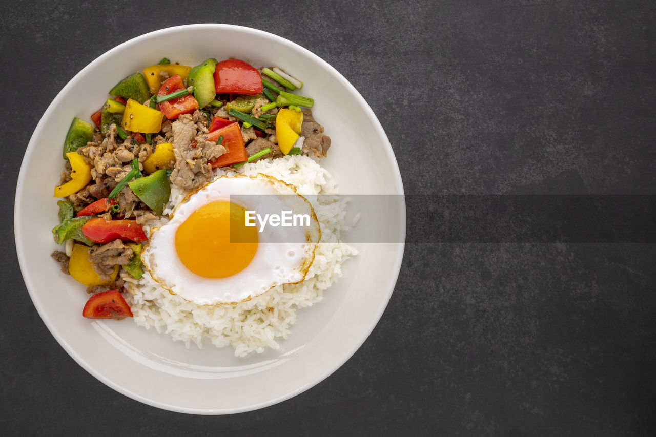 Streamed rice topped with stir fried beef with black pepper, sweet pepper, spring onion and egg