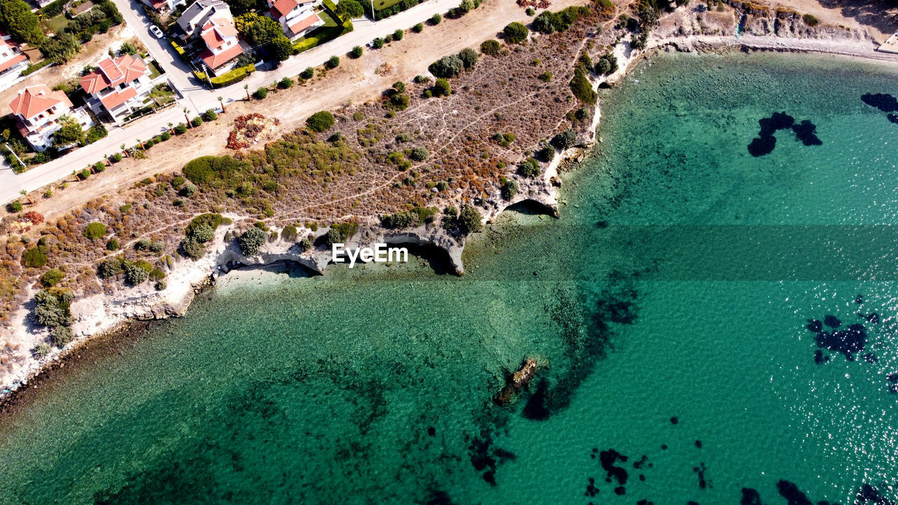 A turkish resort on the aegean coast with summer houses and a rocky bay drone view