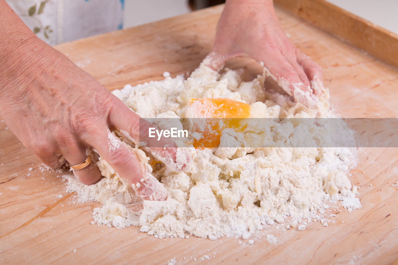 CLOSE-UP OF HAND HOLDING CUTTING BOARD