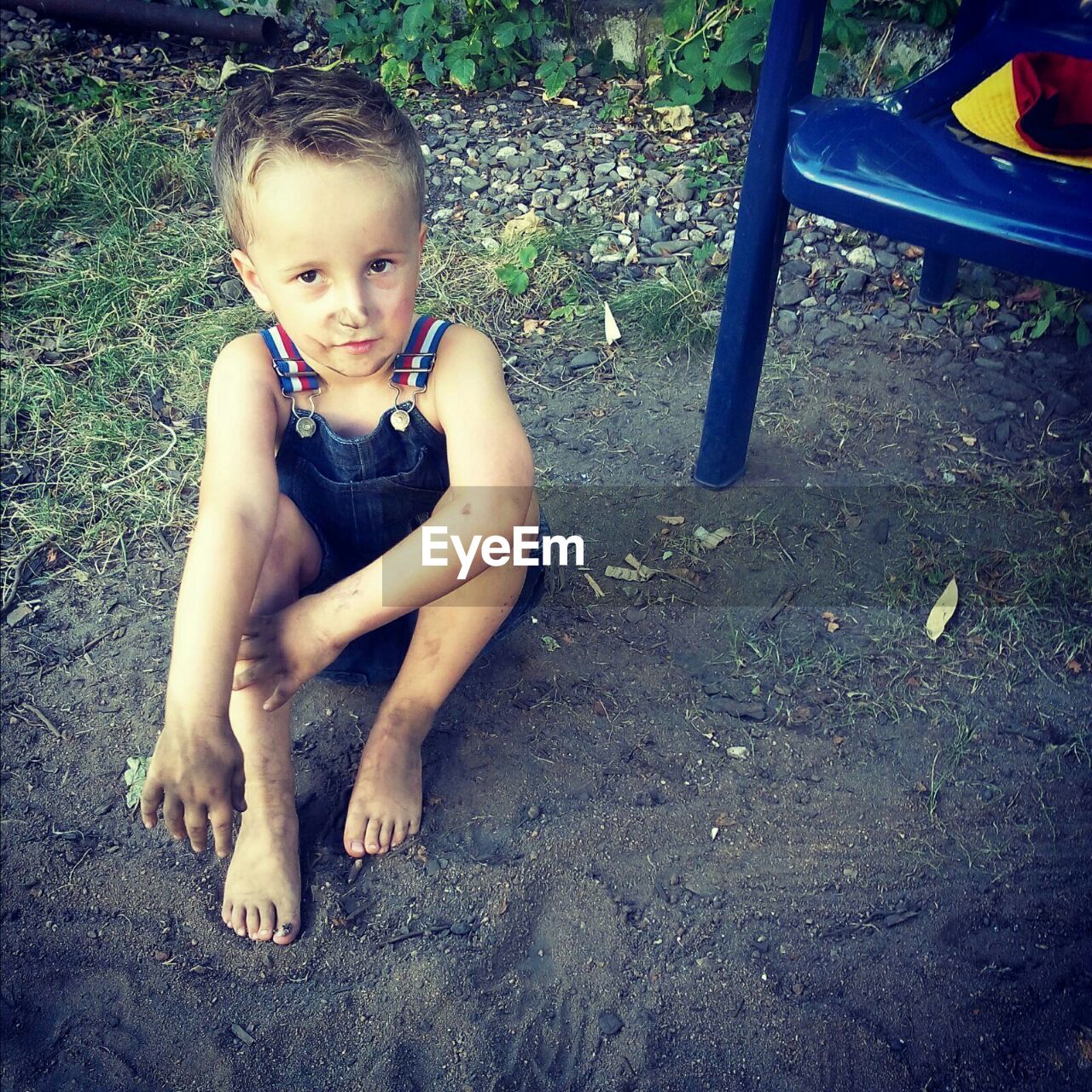 High angle view of boy playing in sand at yard
