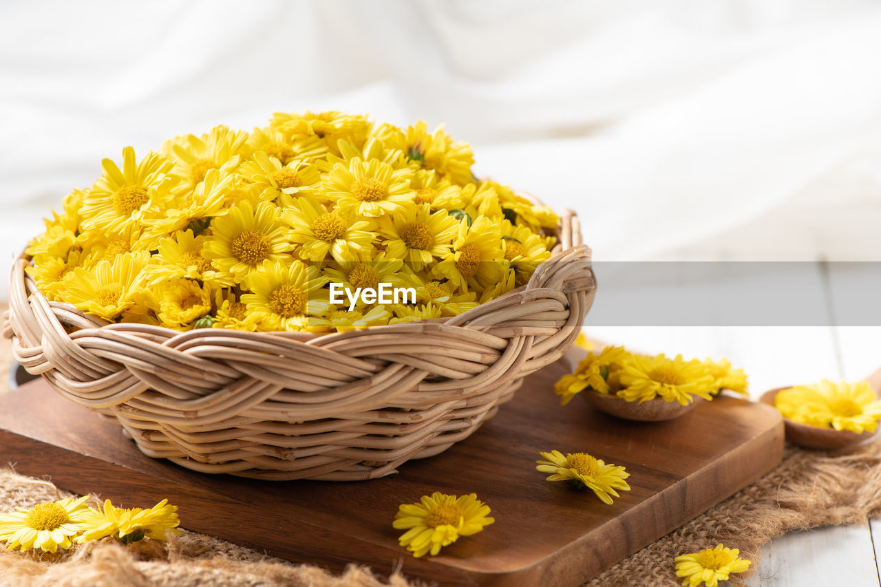 Fresh chrysanthemum flower in basket on a wooden background. chrysanthemum flower 