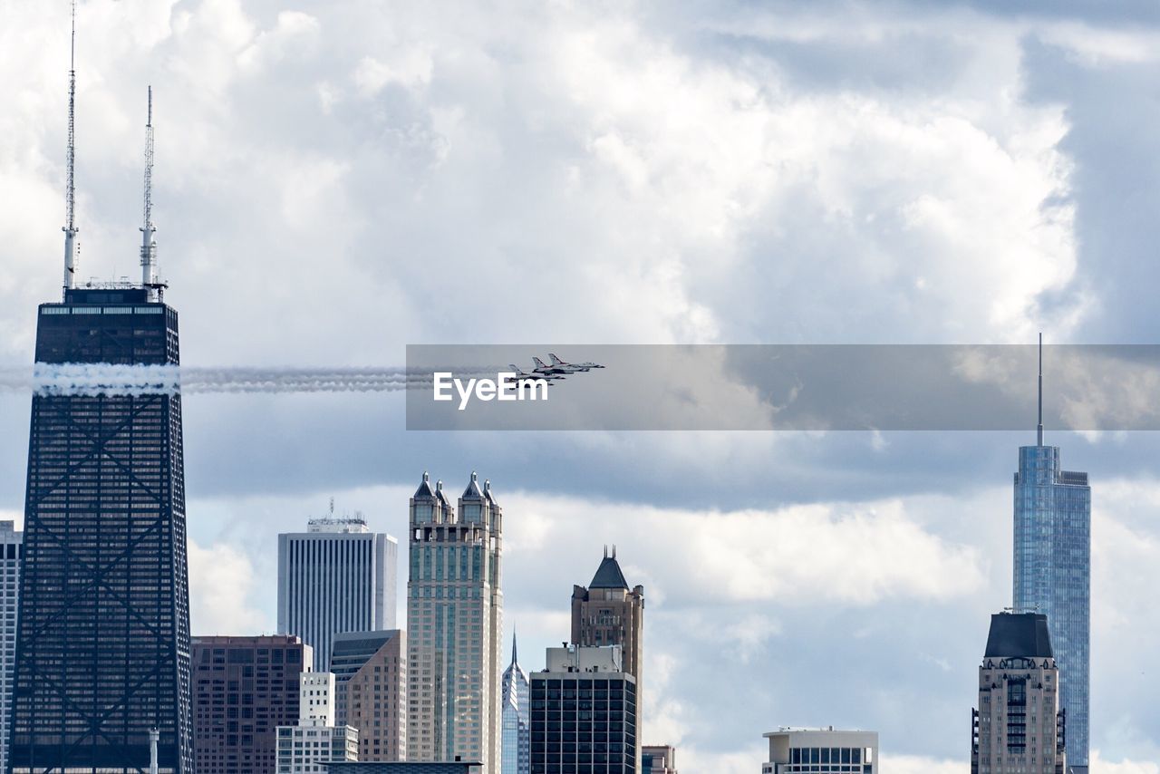 LOW ANGLE VIEW OF MODERN BUILDINGS AGAINST CLOUDY SKY