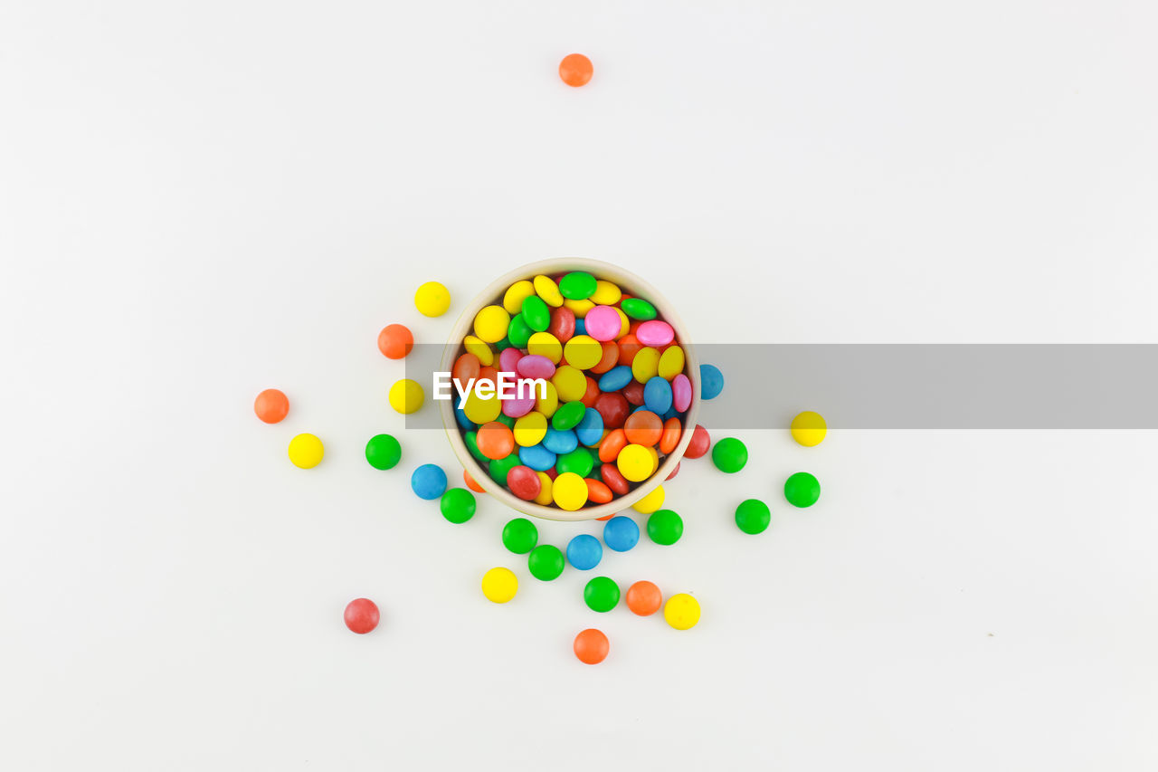 Directly above shot of multi colored candies against white background