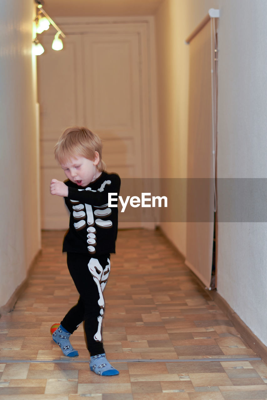 child, childhood, full length, one person, indoors, blond hair, men, standing, innocence, cute, architecture, lifestyles, toddler, casual clothing, corridor, looking, arcade, door, entrance, clothing, home interior, building, spring, flooring, floor, emotion