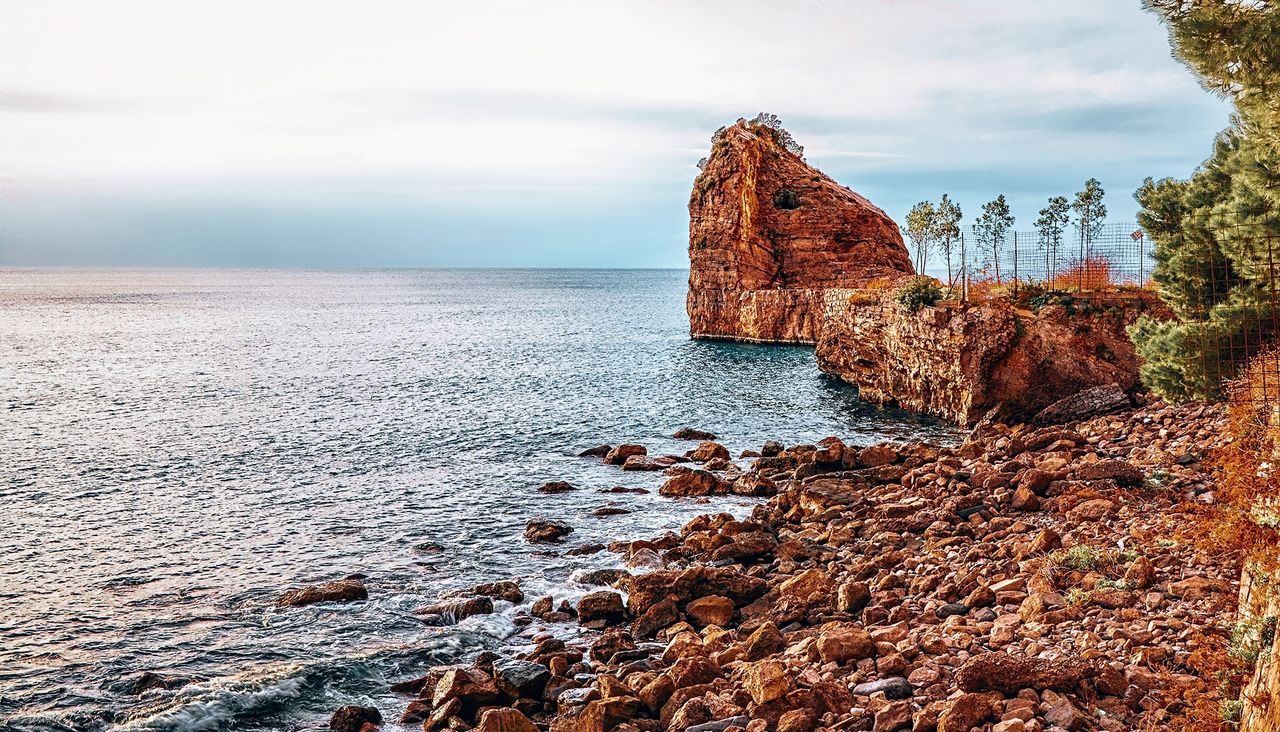 Rock formation in sea against sky