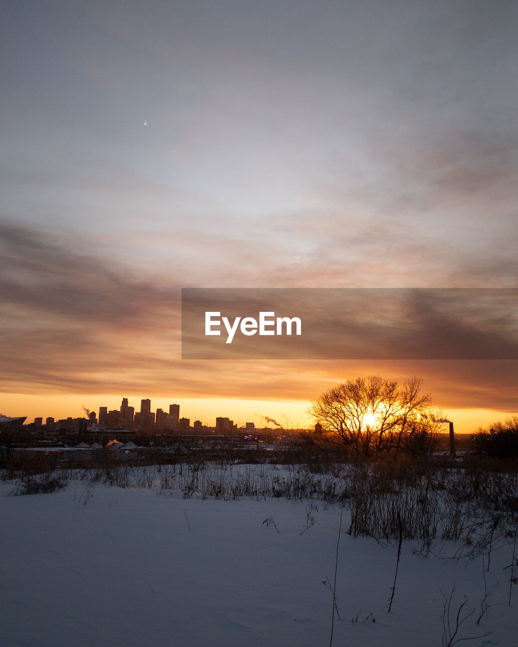 SNOW COVERED FIELD AGAINST SKY DURING SUNSET