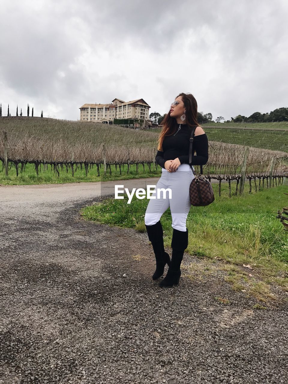 WOMAN STANDING ON FIELD AGAINST SKY