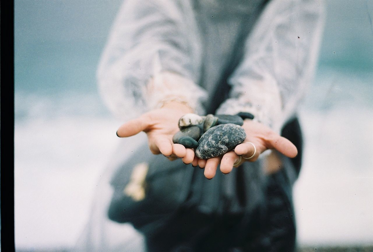 Midsection of woman in raincoat showing stones