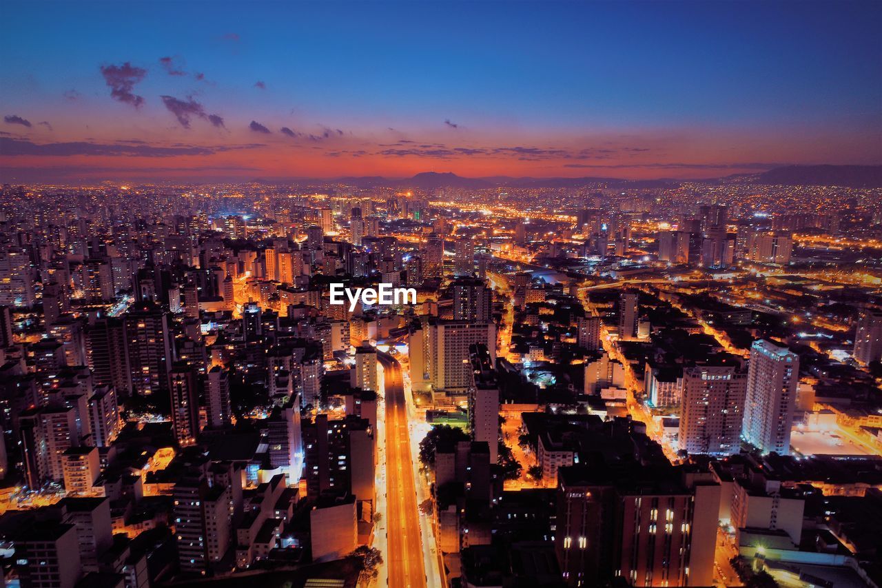 High angle view of illuminated buildings against sky at night