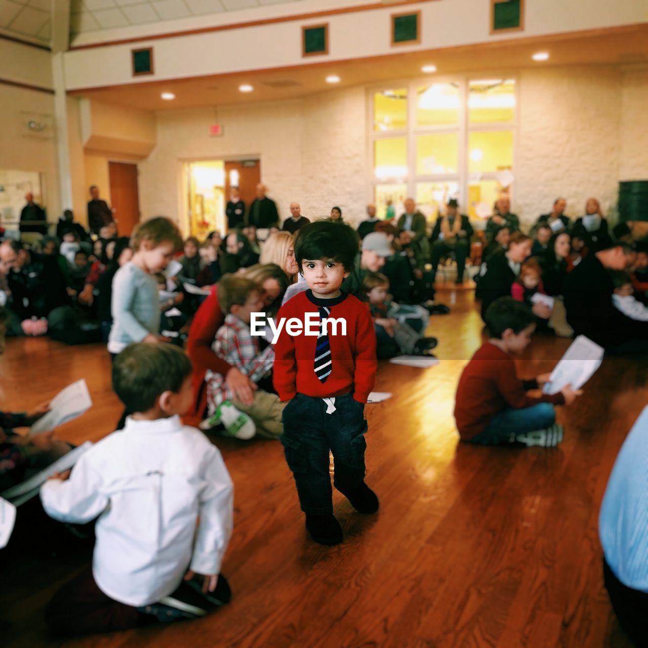 Portrait of boy in school uniform walking in auditorium