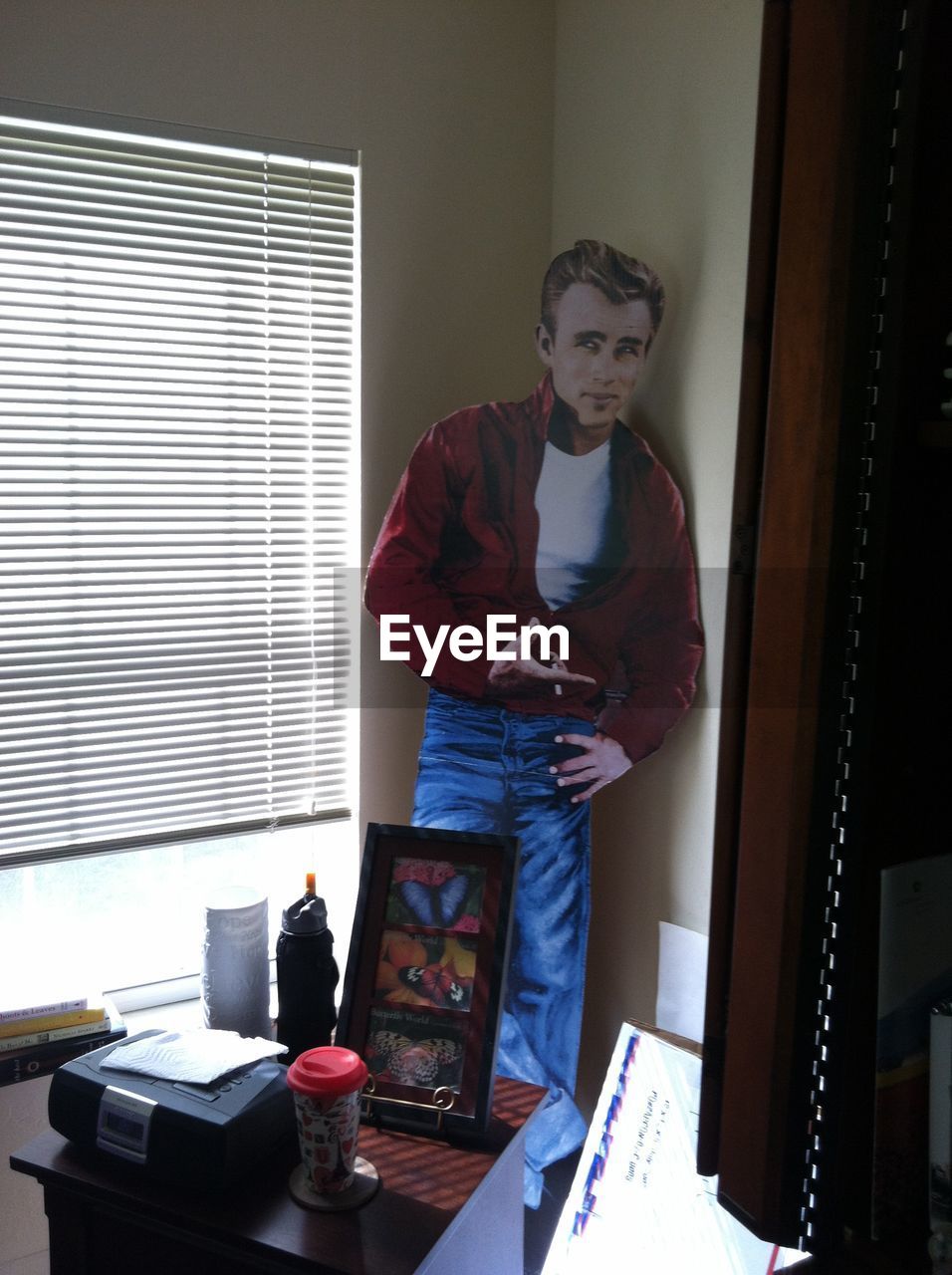 MAN STANDING BY WINDOW AT HOME